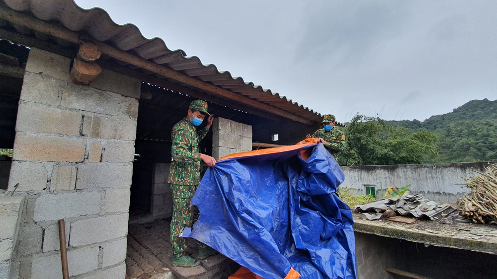 Cán bộ chiến sĩ Đồn Biên phòng Xín Cái giúp người dân che chắn chuồng trại tại thôn Phìn Lò, xã Xín Cái trong những ngày giá rét.