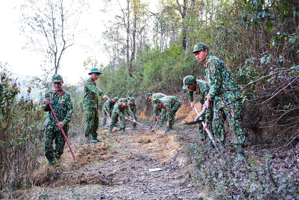 Cán bộ, chiến sĩ Trung đoàn 82 giúp dân bản tu sửa hơn 15 km đường liên bản.