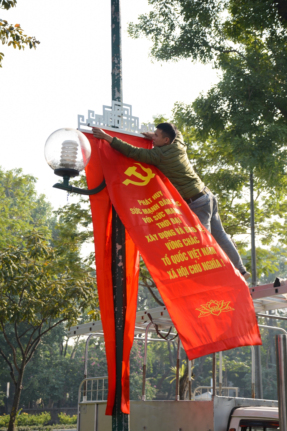 Nhân viên Sở Văn hoá-Thể thao Hà Nội treo băng rôn trên các tuyến phố.