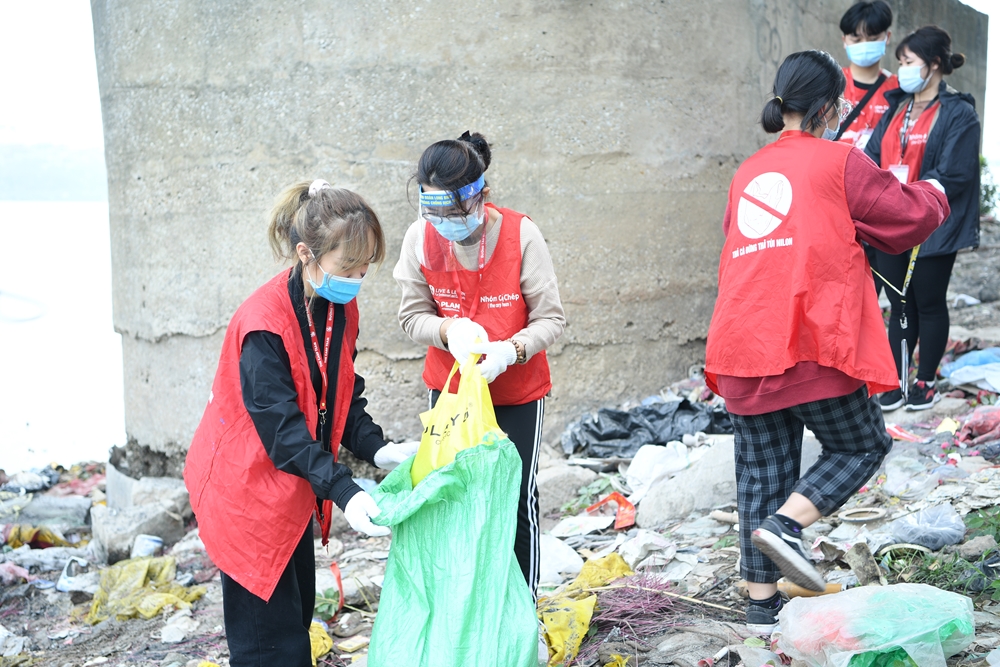 Các thành viên thu gom rác dưới chân cầu Long Biên để xử lý.