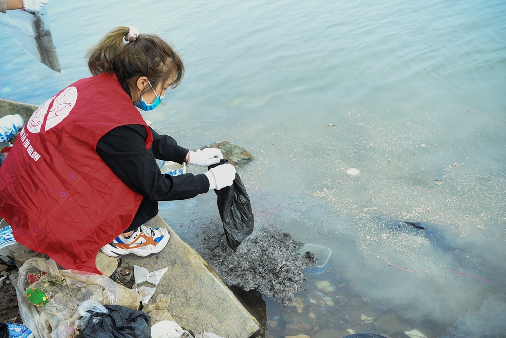 Các bạn tình nguyện nhẹ nhàng thả tro hương xuống sông.