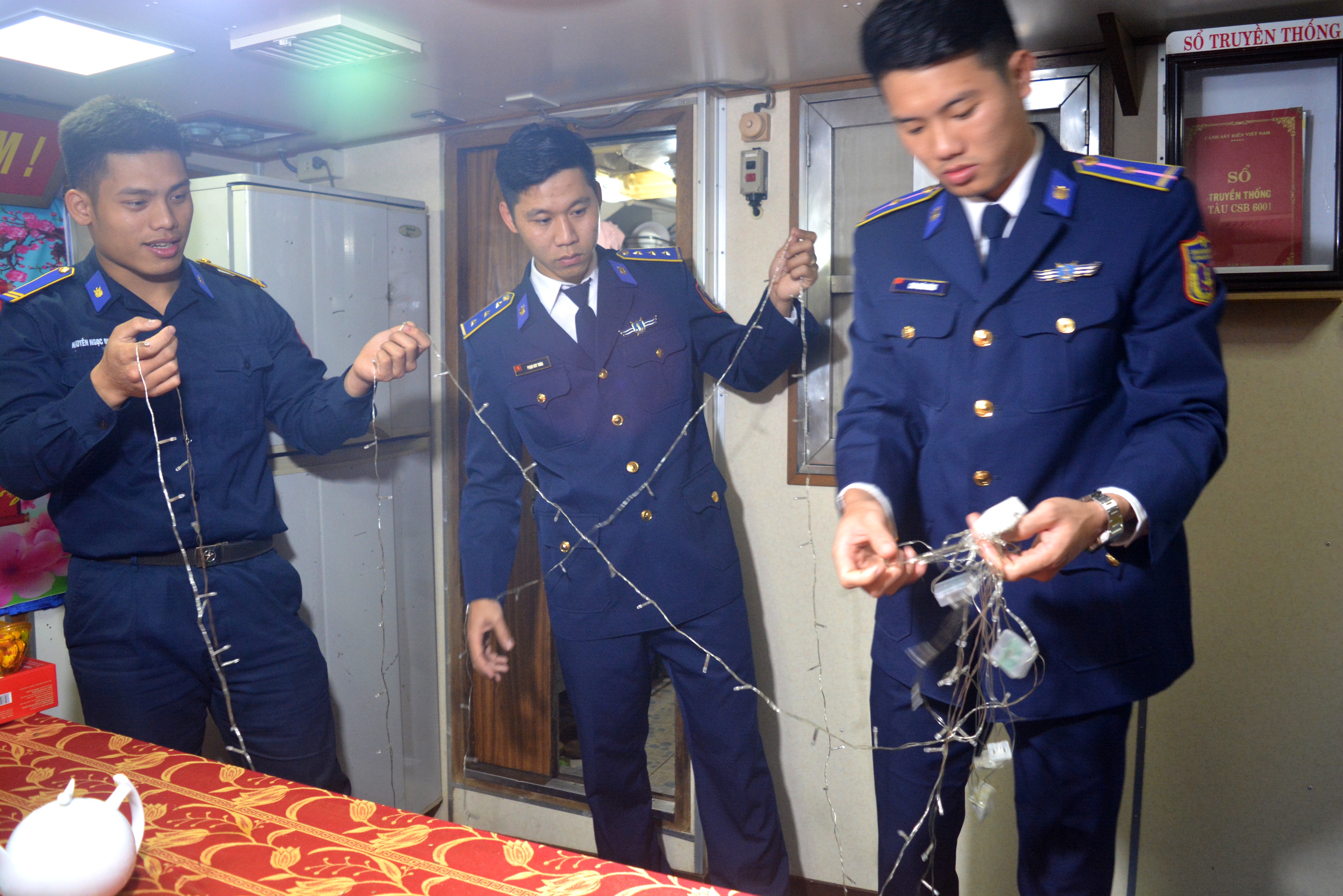 Thượng úy Phạm Huy Toàn, Chính trị viên Tàu Cảnh sát biển 6001 (đứng giữa) cùng bộ đội chuẩn đèn trang trí phòng đón Xuân mới.