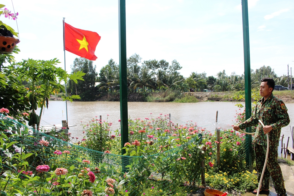 Chiến sĩ Trạm Kiểm soát Biên phòng Nha Sáp, Đồn Biên phòng Vĩnh Điều, BĐBP Kiên Giang chăm sóc khu vực vườn hoa, cây cảnh để đón năm mới. Ảnh: Hồ Phúc.