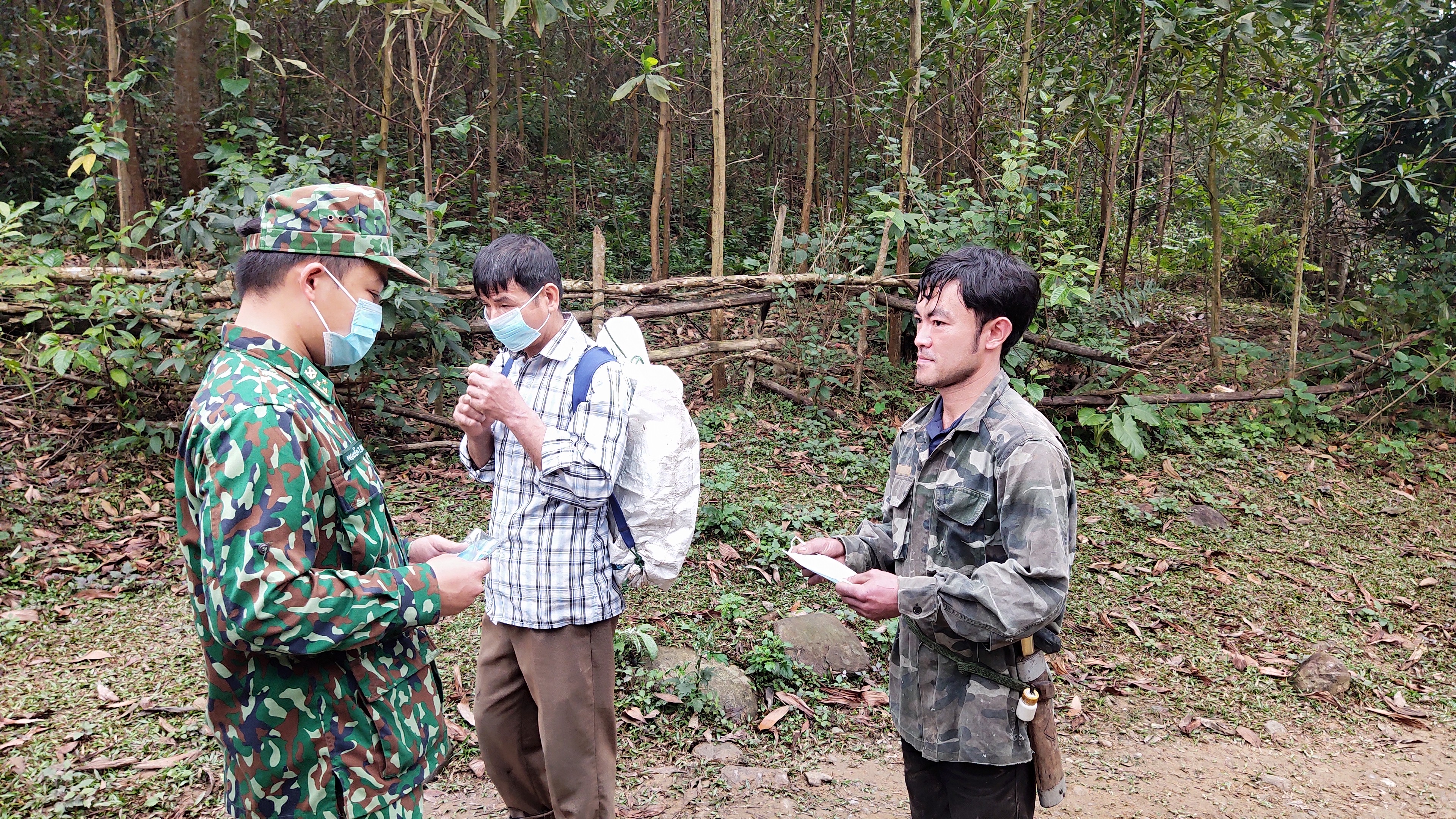 Cán bộ biên phòng Đồn Biên phòng Phú Gia tuyên truyền, phát khẩu trang cho bà con trên địa bàn đi làm trang trại về.