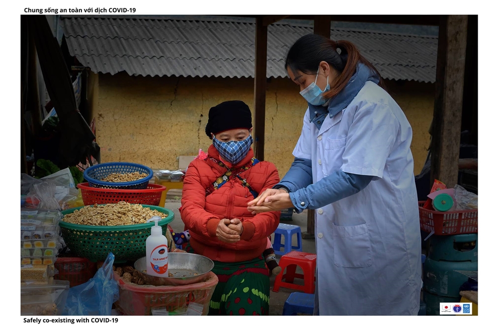 Hướng dẫn bà con tiểu thương rửa tay sát khuẩn tại chợ Sà Phìn.