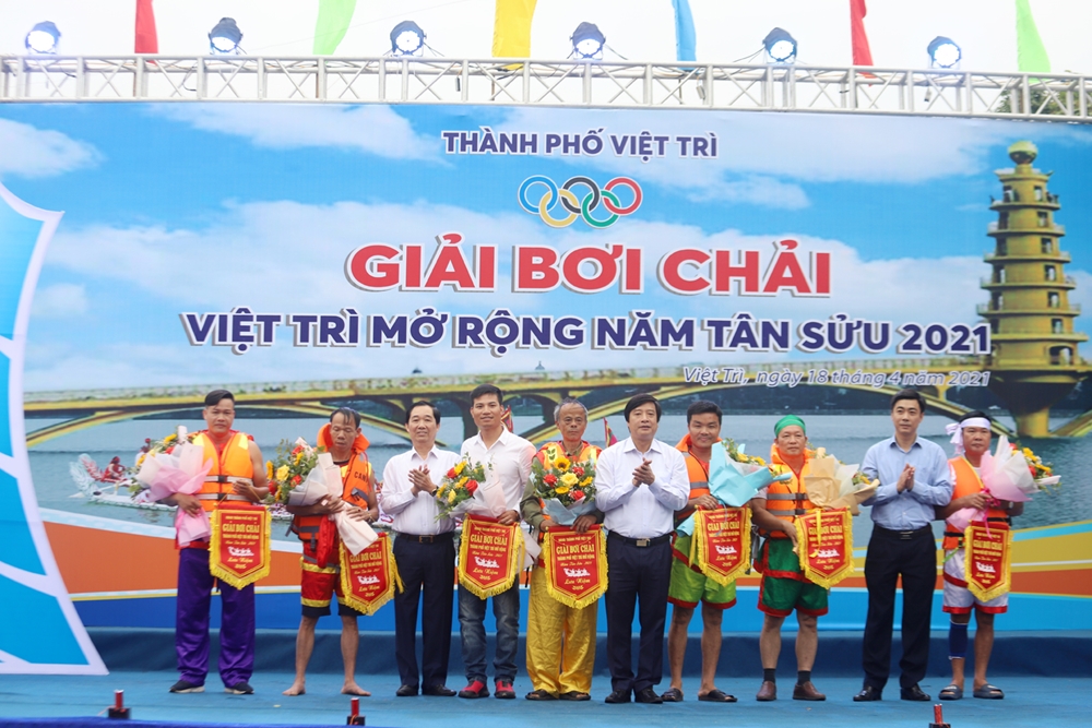Ban tổ chức trao cờ lưu niệm cho các đội chải tham gia giải bơi.