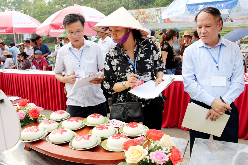 Ban tổ chức chấm điểm các đội sau khi hoàn thành phần thi giã và làm bánh giầy.