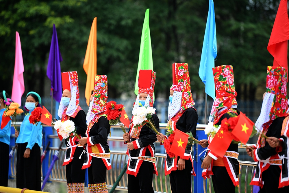 Người dân xã Đồng Văn, huyện Bình Liêu (Quảng Ninh) trong trang phục truyền thống và cờ, hoa rực rỡ chào mừng các đại biểu dự chương trình Giao lưu.