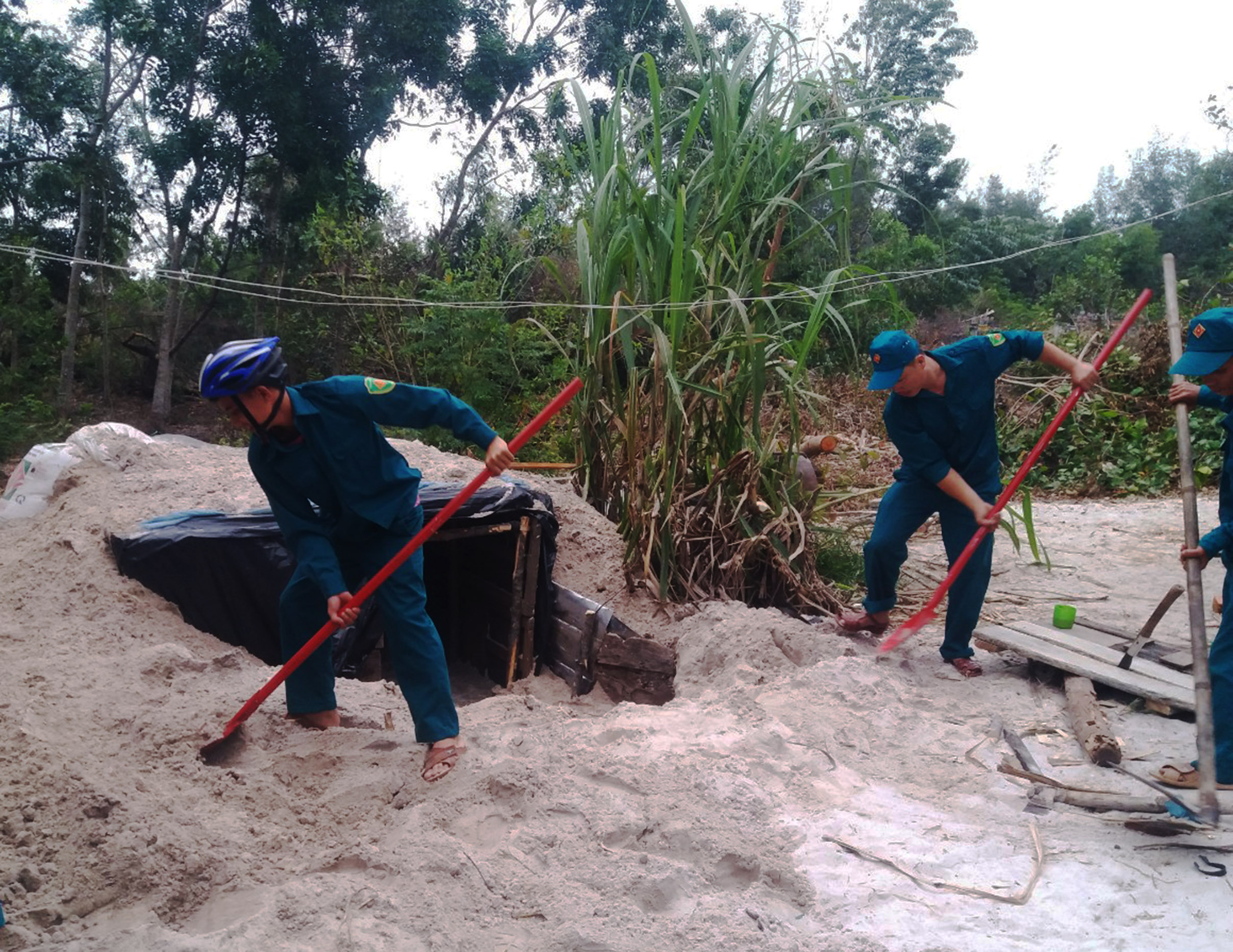 Dân quân giúp dân làm hầm trú, tránh bão