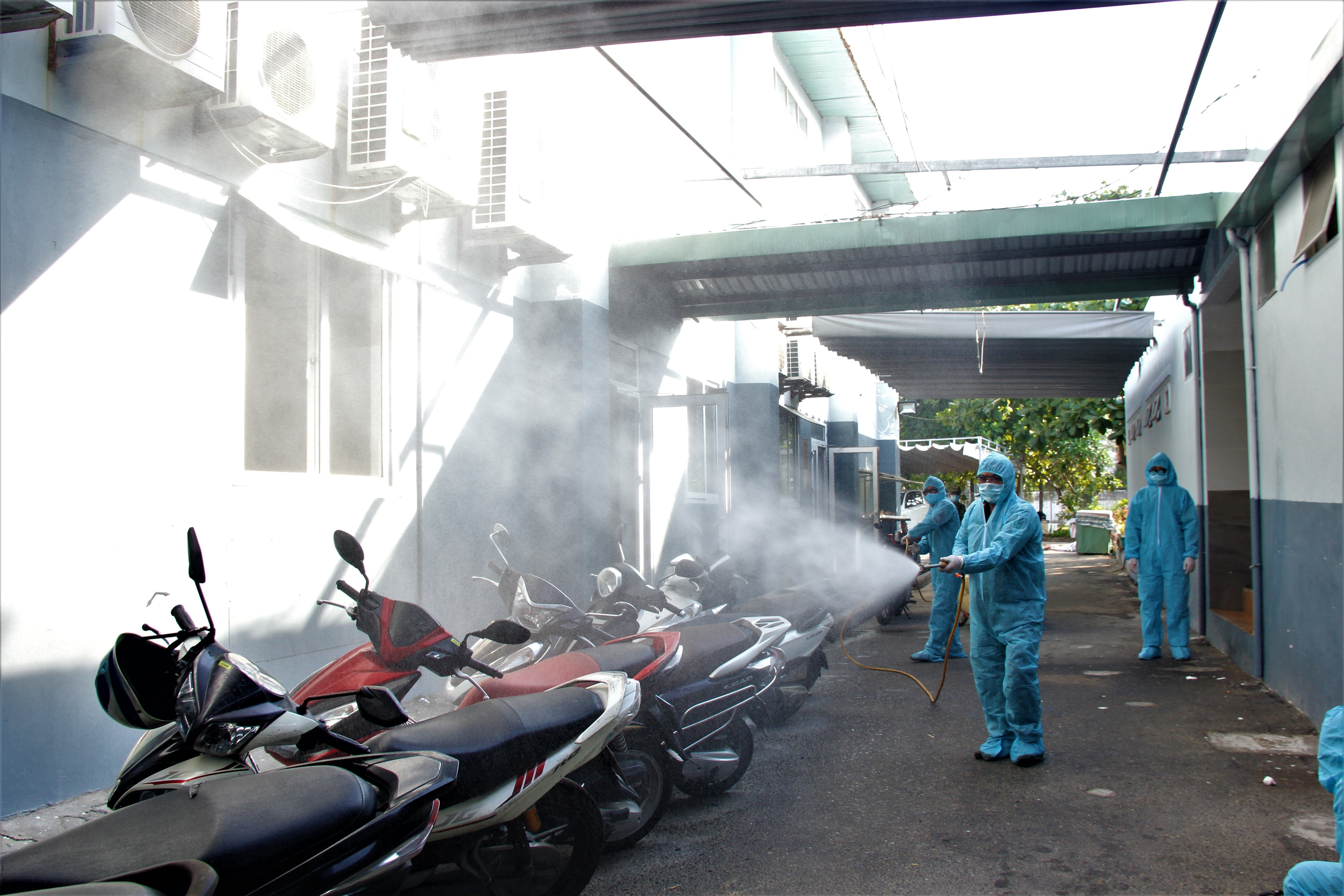 Đội Y học Dự phòng phun khử khuẩn khu để xe của nhân viên nơi có ghi nhận ca nhiễm Covid-19.