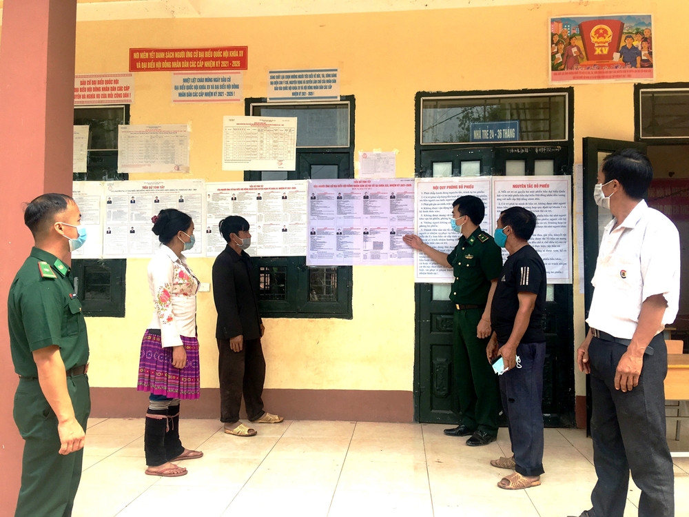 Cán bộ Đồn Biên phòng Na Cô Sa (Bộ đội Biên phòng tỉnh Điện Biên) hướng dẫn dân bản xem danh sách ứng cử viên.