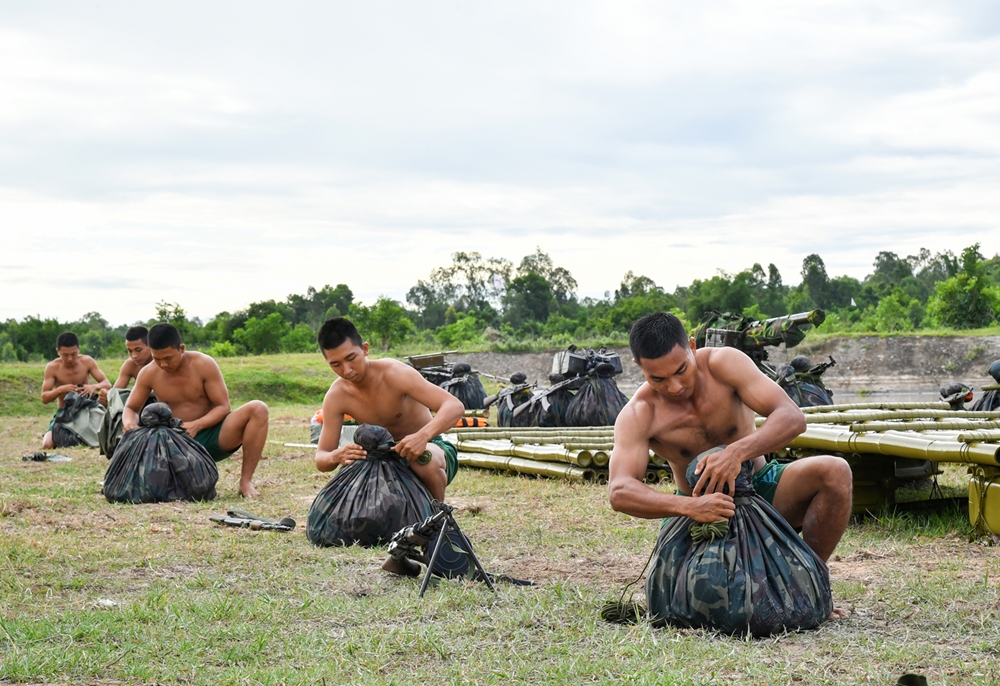 Bộ đội gói buộc vũ khí trang bị chắc chắn trước khi vượt sông.