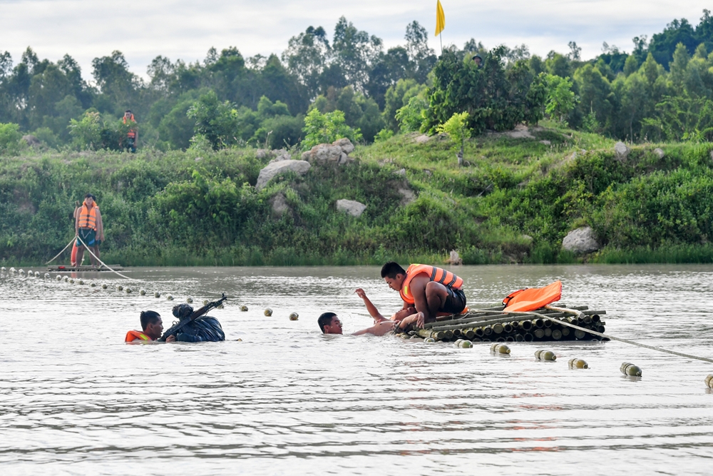 Một thành viên tổ bảo vệ đưa đồng đội lên bè, thành viên khác thì vớt trang bị.