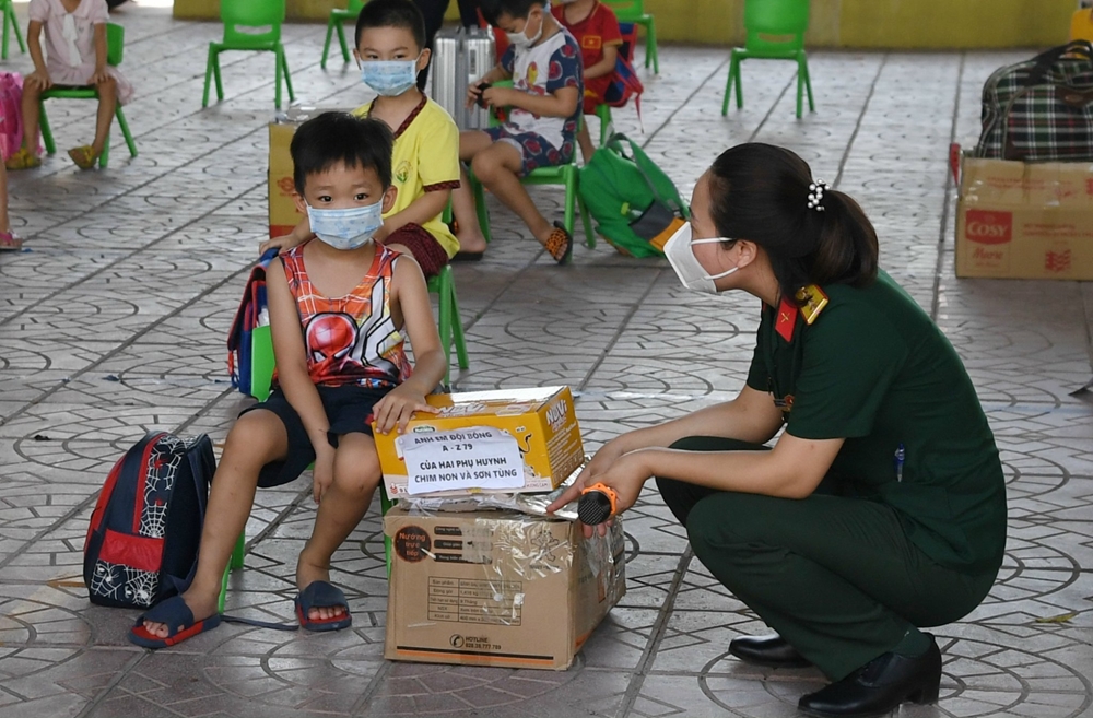 Nữ quân nhân cũng tham gia các khung cách ly, chăm có công dân diện F1. Trong ảnh: Một nữ quân nhân thuộc Ban CHQS TP Bắc Giang động viên các cháu bé trước khi hết hạn cách ly.