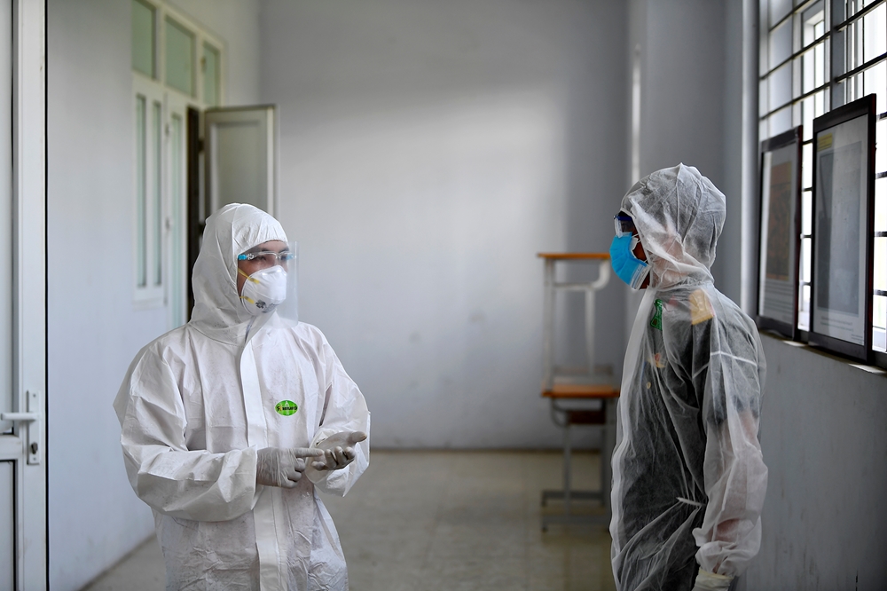 Nhân viên y tế trao đổi với cán bộ Ban CHQS huyện Việt Yên về công tác bảo đảm cách ly công dân.