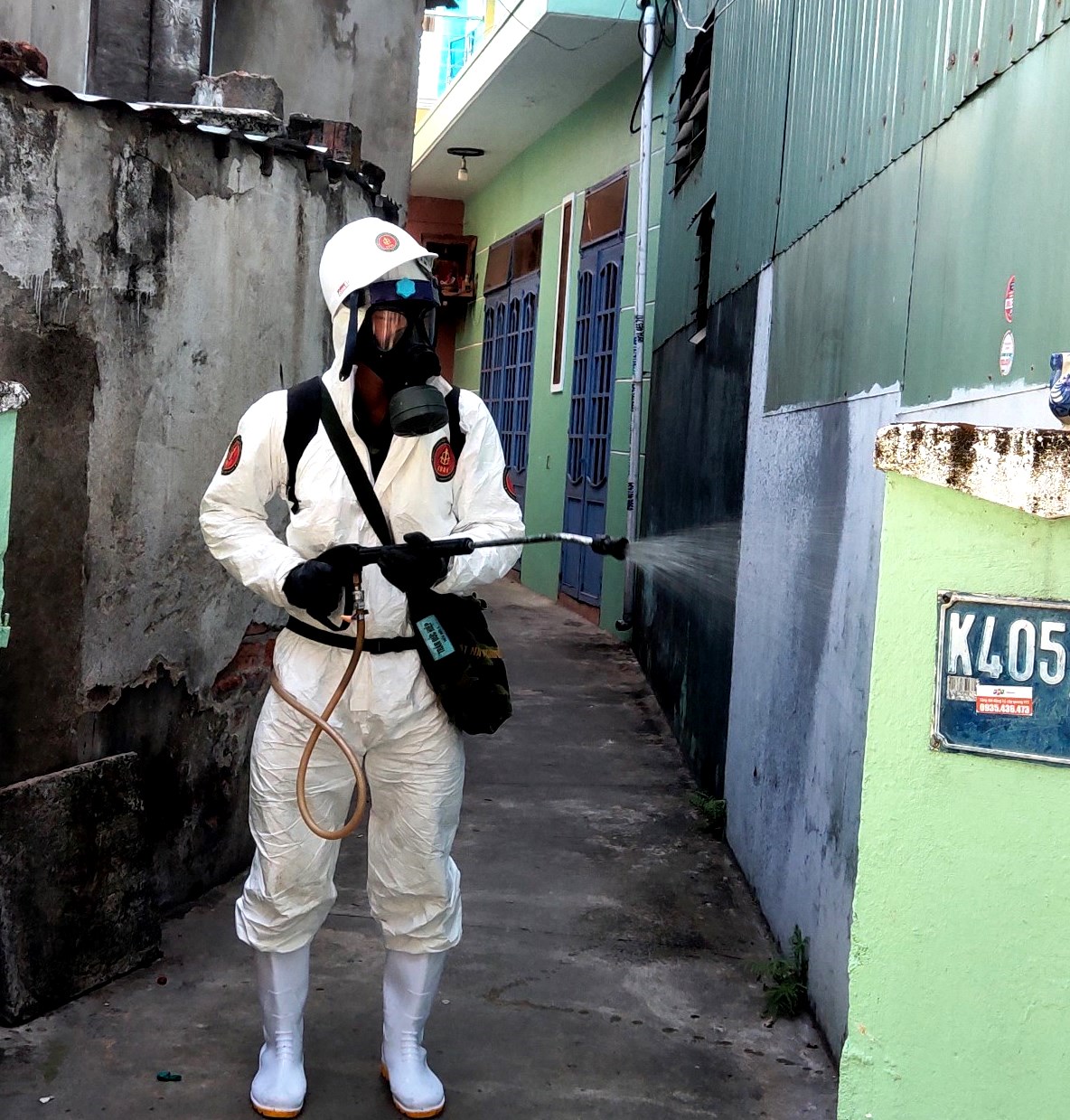 Sử dụng bình đeo lưng phun khử khuẩn các hẻm nhỏ.