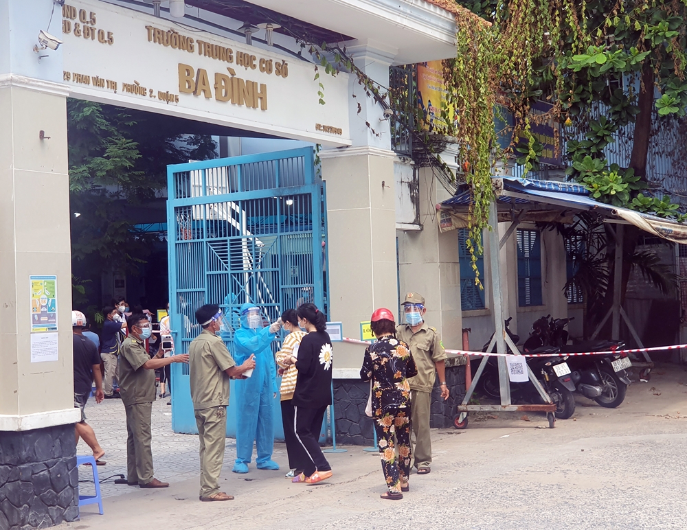 Gần 12 giờ trưa, việc lấy mẫu xét nghiệm vẫn đang được lực lượng chức năng thực hiện tại điểm Trường THCS Ba Đình, quận 5.