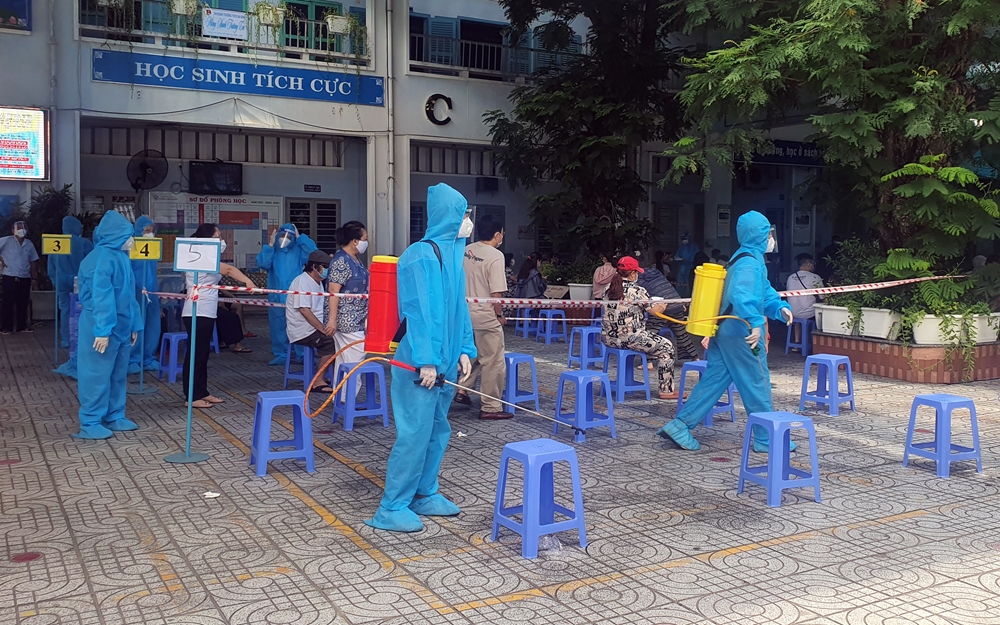 Nhân viên y tế phun xịt khử khuẩn liên tục khu vực tập trung chờ đợi lấy mẫu.