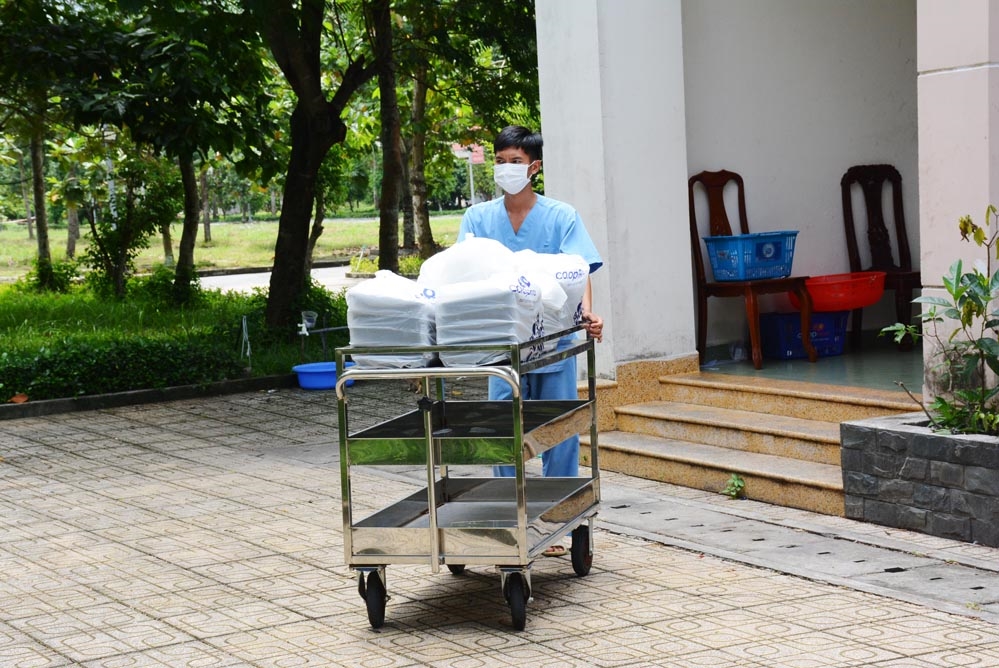 Đưa suất ăn đến các phòng phục vụ bệnh nhân.