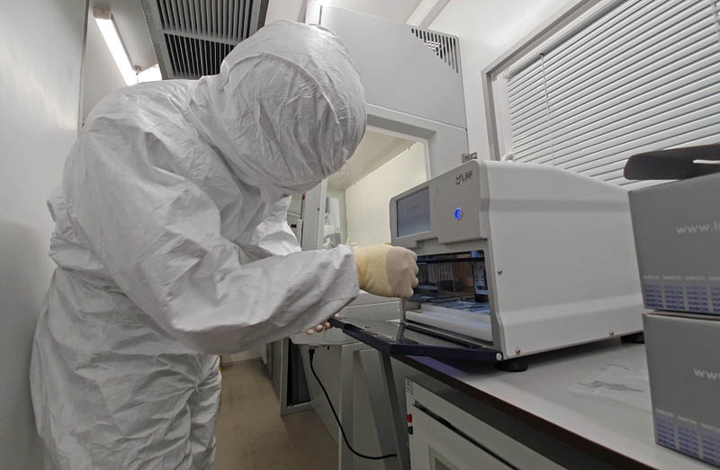 Đại úy, bác sĩ chuyên khoa 1 Lê Văn Cường chuyển mẫu vào máy RT-PCR trên xe labo di động.