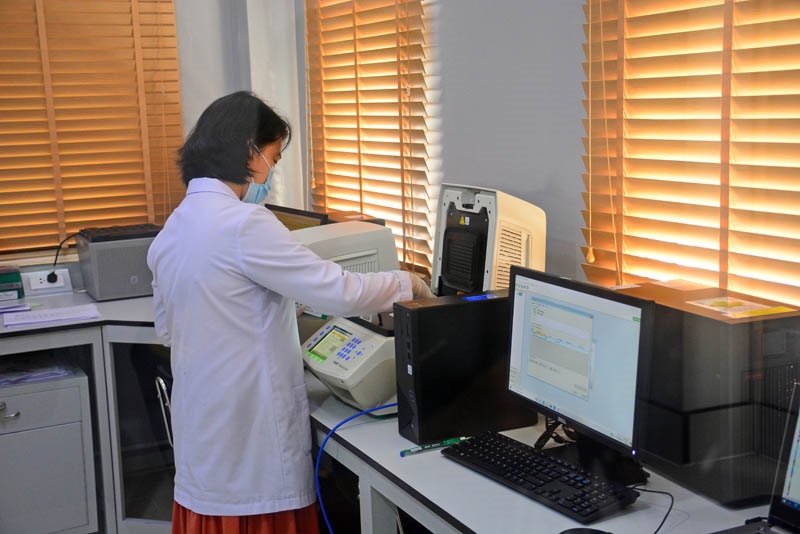 Trung tá, TS Lương Thị Mơ, Trưởng phòng Y sinh nhiệt đới, Chi nhánh phía Nam Trung tâm Nhiệt đới Việt – Nga đưa mẫu vào máy chạy RT-PCR để cho kết quả cuối cùng xét nghiệm Covid-19.