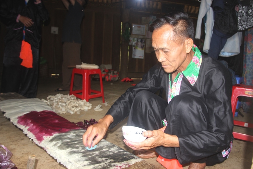 Thầy cúng chuẩn bị giấy màu để dùng trong Lễ Dù Su.