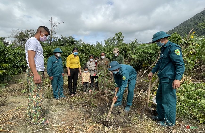 Dân quân thường trực xã Krông Nô hướng dẫn bà con M’Nông, buôn Trang Yốc trồng xen sầu riêng trong vườn cà phê.