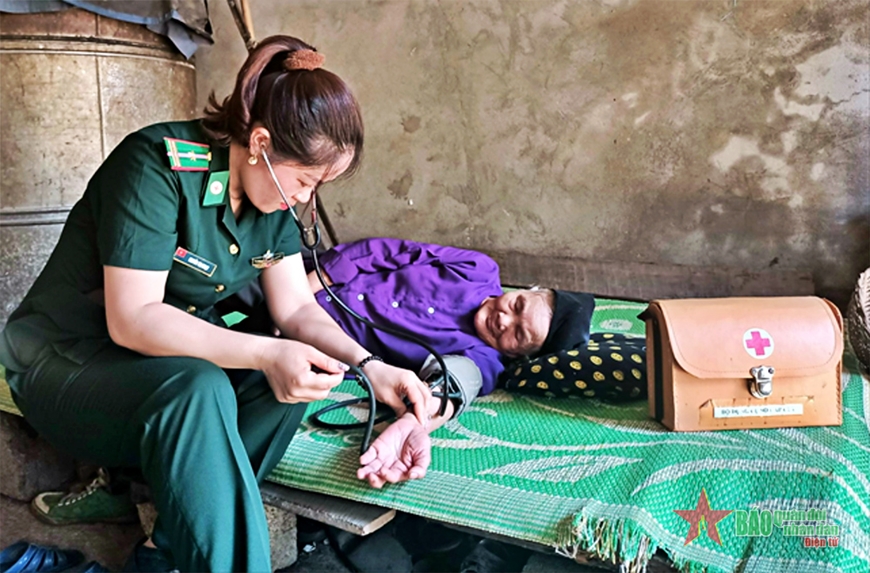 Thiếu tá QNCN Nguyễn Thị Ngoạt khám bệnh cho người dân trên địa bàn đơn vị đóng quân.