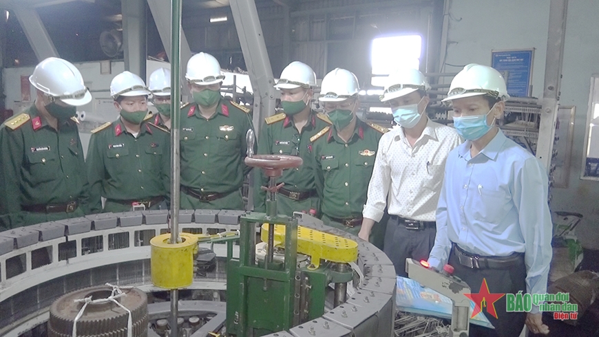 Đồng chí Phạm Trung Kiên (ngoài cùng, bên phải) báo cáo hoạt động và hiệu quả của sáng kiến "Chế tạo hệ thống mài tròn vòng lược máy dệt" tại dây chuyền sản xuất.