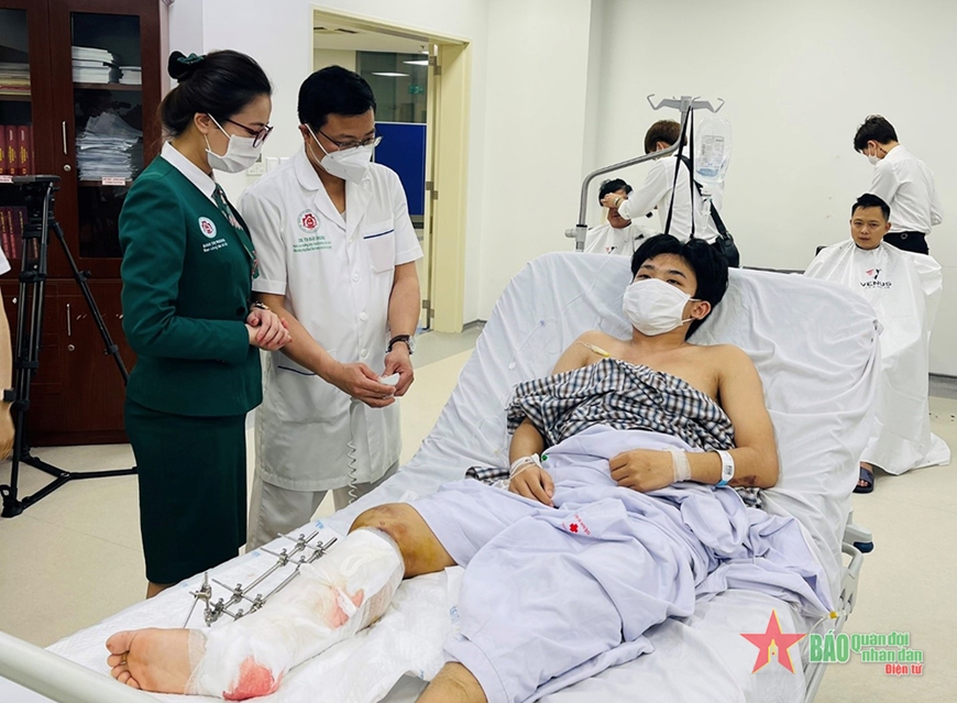 Nữ nhân viên Ban Công tác xã hội Bệnh viện Trung ương Quân đội 108 thăm hỏi, động viên bệnh nhân. Ảnh: AN NGỌC