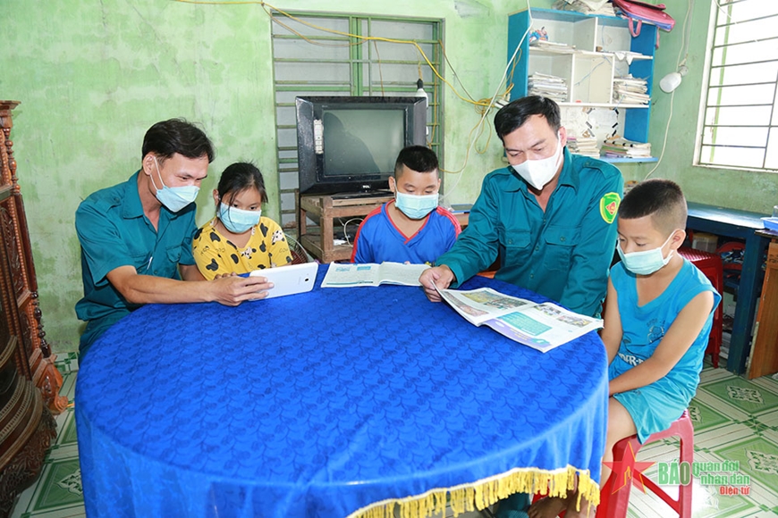 Dân quân xã Tam Nghĩa hướng dẫn các cháu mồ côi học bài.