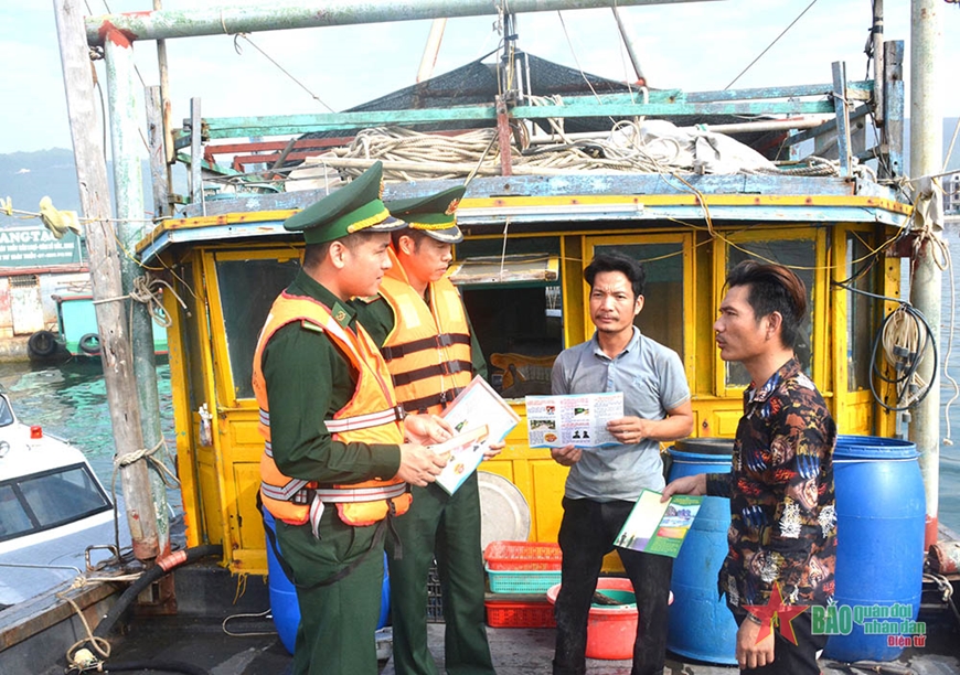 Thượng úy Hoàng Văn Phong (ngoài cùng, bên trái) tuyên truyền, phổ biến, giáo dục pháp luật cho ngư dân.