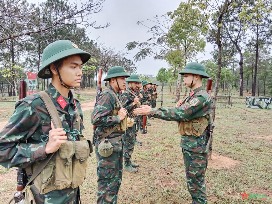 Đồng chí Tiểu đội trưởng, kiểm tra và chỉnh sửa cho chiến sĩ mới, trong đội hình thực hiện động tác mang súng đúng kỹ thuật, trước khi bước vào nội dung huấn luyện. 