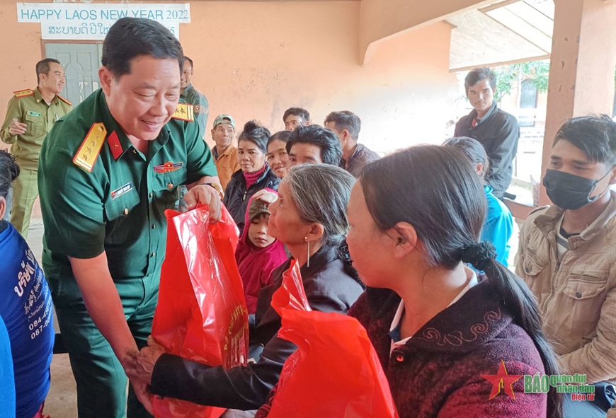 Đại tá Nguyễn Xuân Sơn tặng quà cho người dân Lào. 