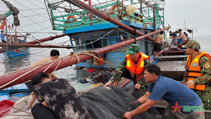   Cán bộ, chiến sĩ Đồn Biên phòng Roòn phối hợp với lực lượng ứng cứu tàu QB93786 TS bị chìm trên biển. Ảnh HOÀI NAM