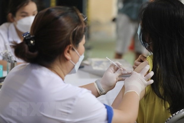  Nhân viên y tế tiêm vắc xin cho học sinh.