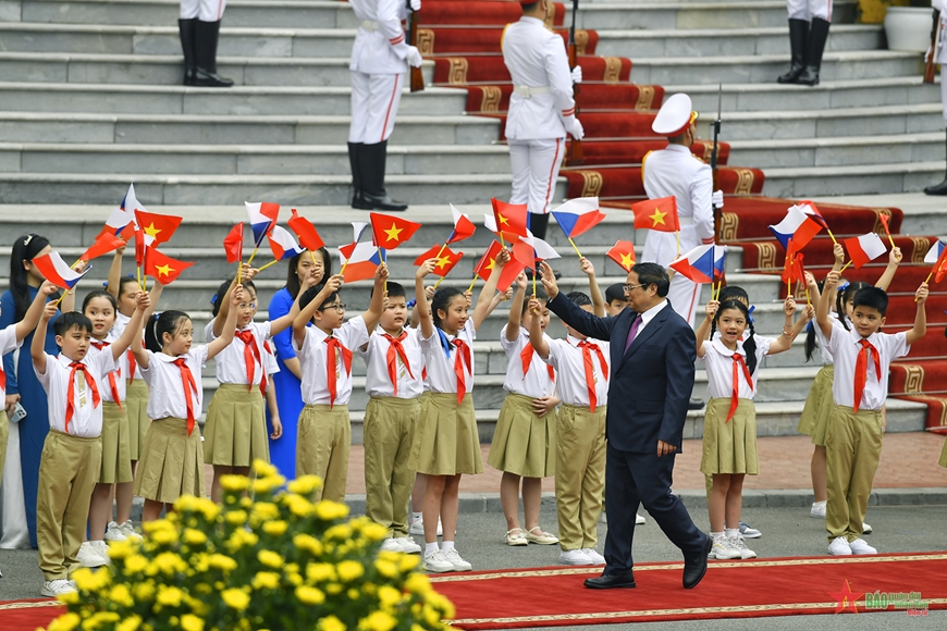 Các cháu học sinh vẫy cờ chào đón Thủ tướng Phạm Minh Chính. Ảnh: TUẤN HUY  
