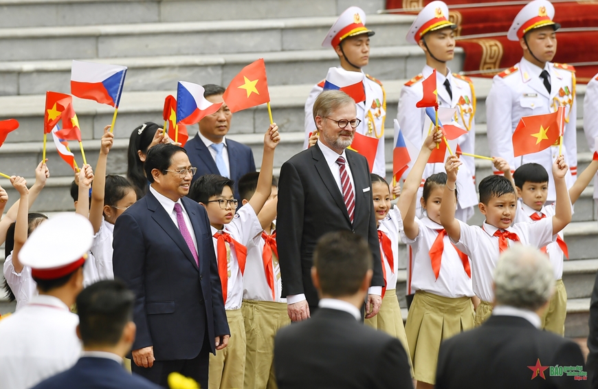 Các cháu học sinh vẫy cờ chào đón Thủ tướng Phạm Minh Chính và Thủ tướng Petr Fiala. Ảnh: TUẤN HUY