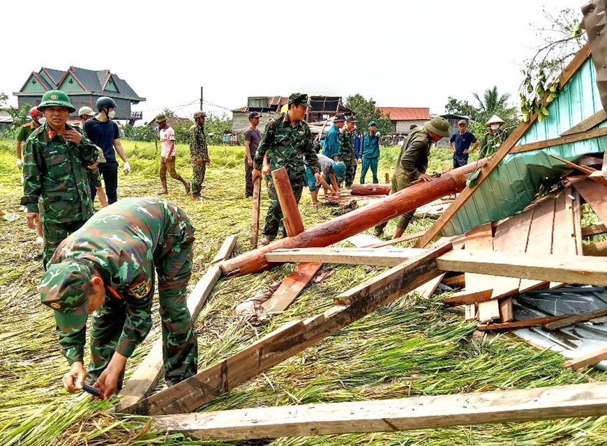 Cán bộ, chiến sĩ Ban CHQS huyện Phú Thiện và lực lượng dân quân giúp người dân dựng lại nhà bị đổ. 