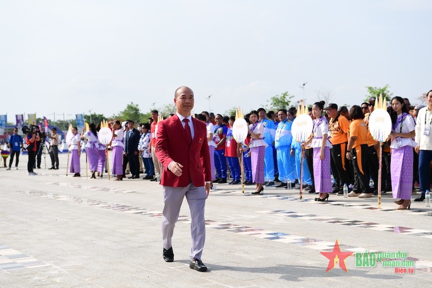 Ông Hoàng Quốc Vinh di chuyển lên khu vực khán đài thực hiện nghi lễ thượng cờ của đoàn thể thao Việt Nam. 