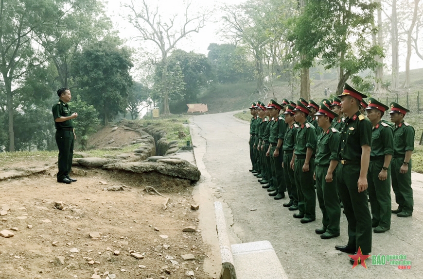 Cán bộ, chiến sĩ Tiểu đoàn 1, Trung đoàn 741 được nghe cựu chiến binh Vũ Xuân Thạch kể chuyện truyền thống tại Đồi A1. Ảnh: ĐỨC HẠNH 