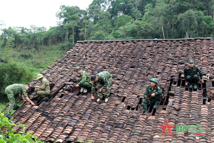 Cán bộ, nhân viên Ban CHQS huyện Quảng Hòa giúp nhân dân xã Phi Hải lợp lại mái nhà. 