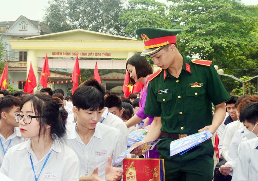 Học viên Trường Sĩ quan Chính trị và giáo viên Trường THPT Lê Quý Đôn (huyện Trấn Yên, tỉnh Yên Bái) phát tài liệu tư vấn tuyển sinh quân sự đến học sinh. 