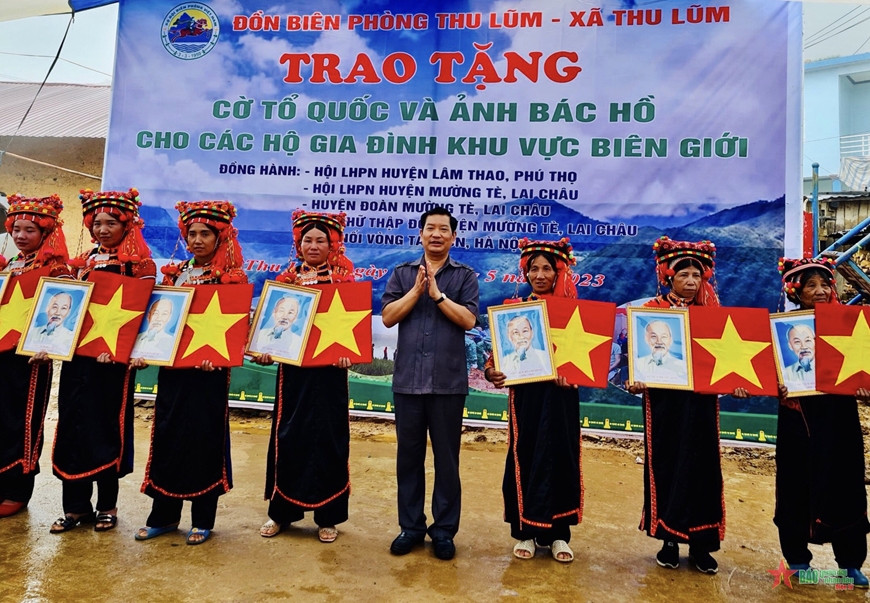 Đồng chí Chu Lê Chinh, Phó chủ tịch HĐND tỉnh Lai Châu trao cờ Tổ quốc và ảnh Bác Hồ tặng người dân bản Pa Thắng. 