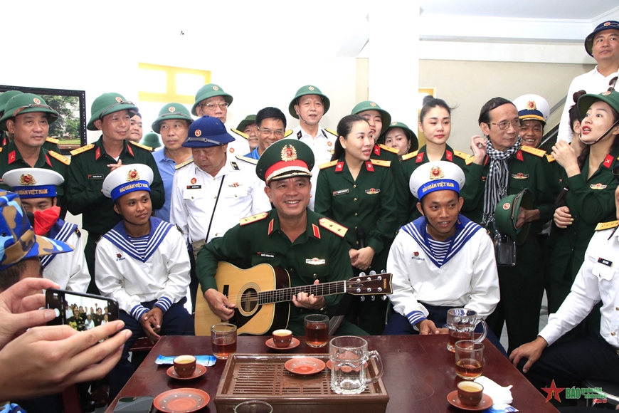  Trung tướng Nguyễn Trường Thắng, Tư lệnh Quân khu 7 ôm đàn ghi ta vừa đàn và bắt nhịp các bài hát để đại biểu cùng chiến sĩ cất cao lời ca tiếng hát trên đảo Đá Tây C.