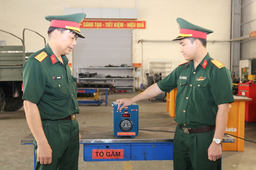 Thiếu tá Đặng Trung Kiên, Trưởng ban Tham mưu kỹ thuật Xưởng X81 (bên phải) giới thiệu “Thiết bị kiểm tra và quy “0” đồng hồ tốc độ xe ô tô quân sự”. 