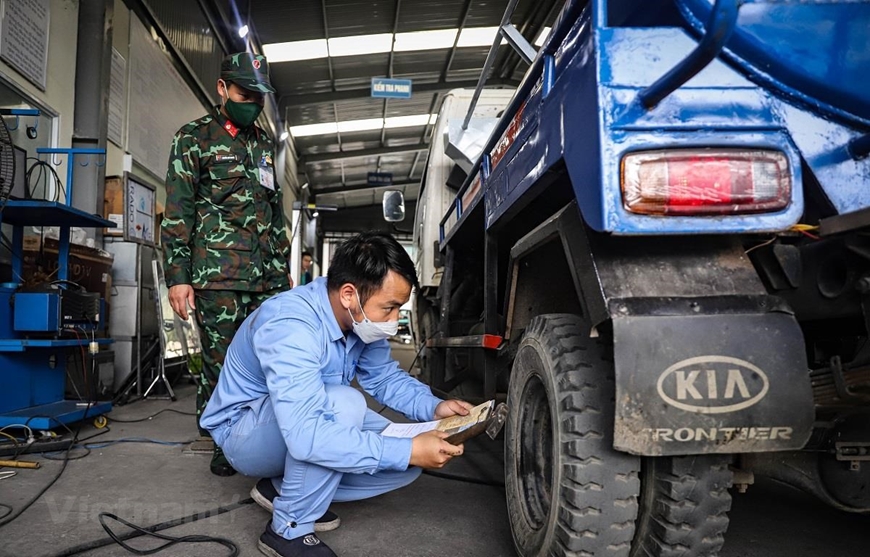 Nhân viên đăng kiểm tiến hành quy trình kiểm định xe cơ giới. Ảnh: Vietnam+ 