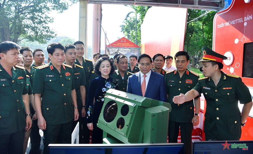 Thủ tướng Phạm Minh Chính và các đại biểu tham quan khu trưng bày sản phẩm tuổi trẻ sáng tạo trong Quân đội. 