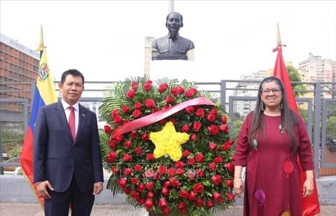 Đại sứ Vũ Trung Mỹ và Thứ Ngoại giao Venezuela Tatiana Pugh dâng hoa tại tượng đài Chủ tịch Hồ Chí Minh.