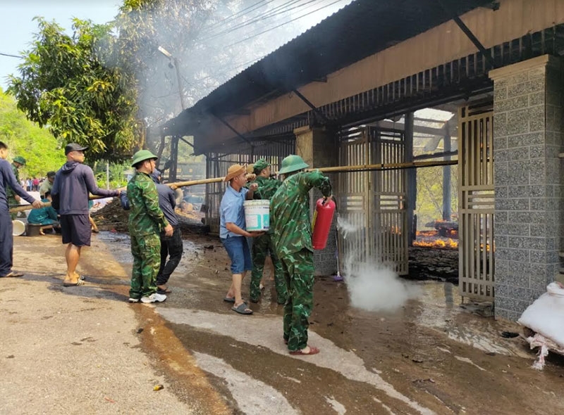 Cán bộ, chiến sĩ Đồn Biên phòng Mỹ Lý sử dụng thiết bị tham gia chữa cháy nhà dân.